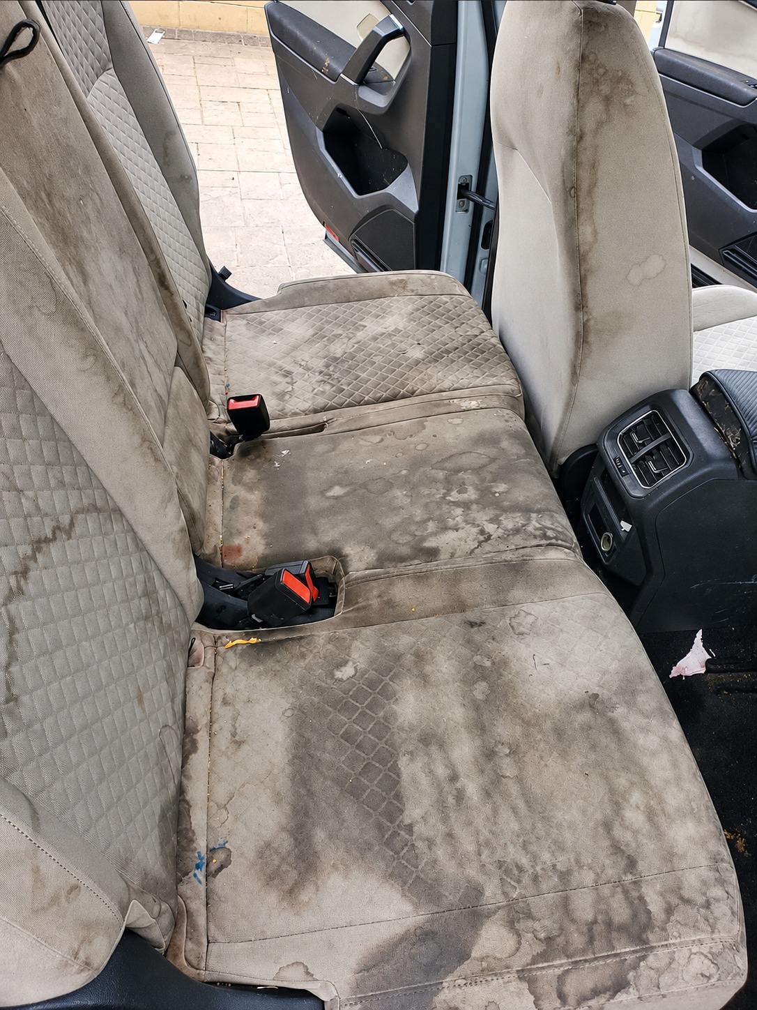 Light cloth rear seats with widespread staining before detailing